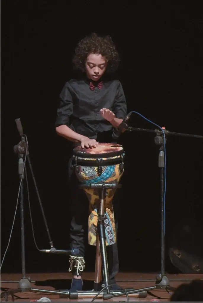 Aurum performing on the djembe, full length