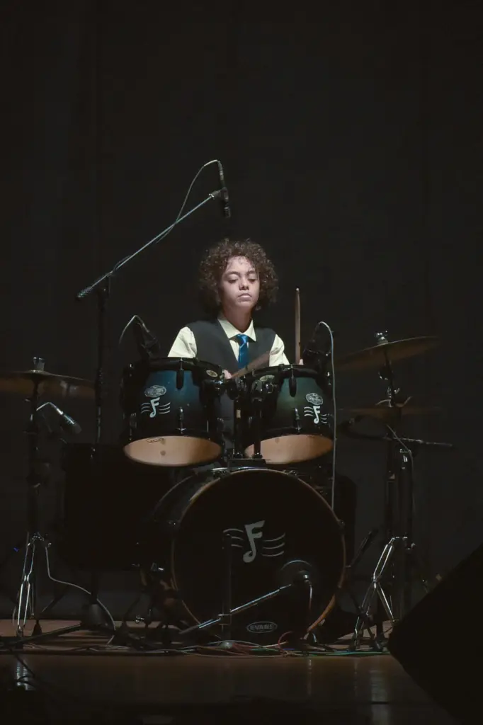 Aurum at the drum kit on a dark stage